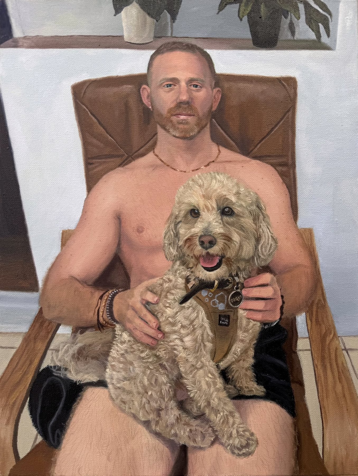 Oil portrait of Anthony in a leather chair holding Natty, a cream cockapoo